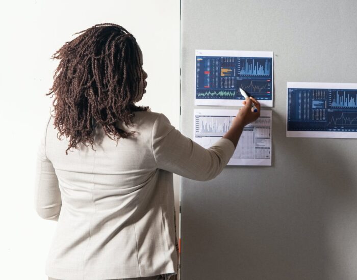 photo of a woman with curly hair pointing at a paper with a graph