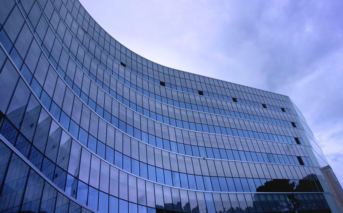 fish eye view photo of glass high story building over white cloudy sky during daytime