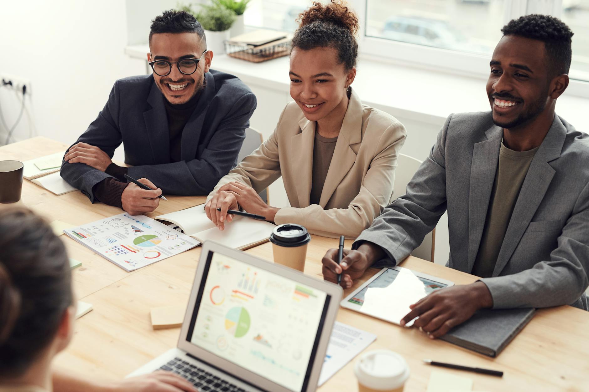 photo of three people smiling while having a meeting