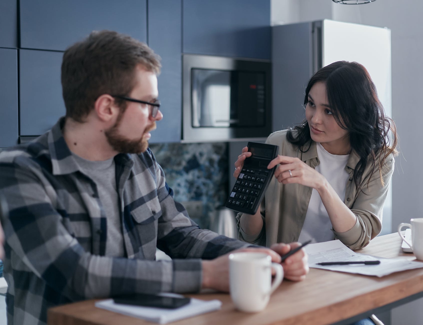 couple sitting at table with cups and papers