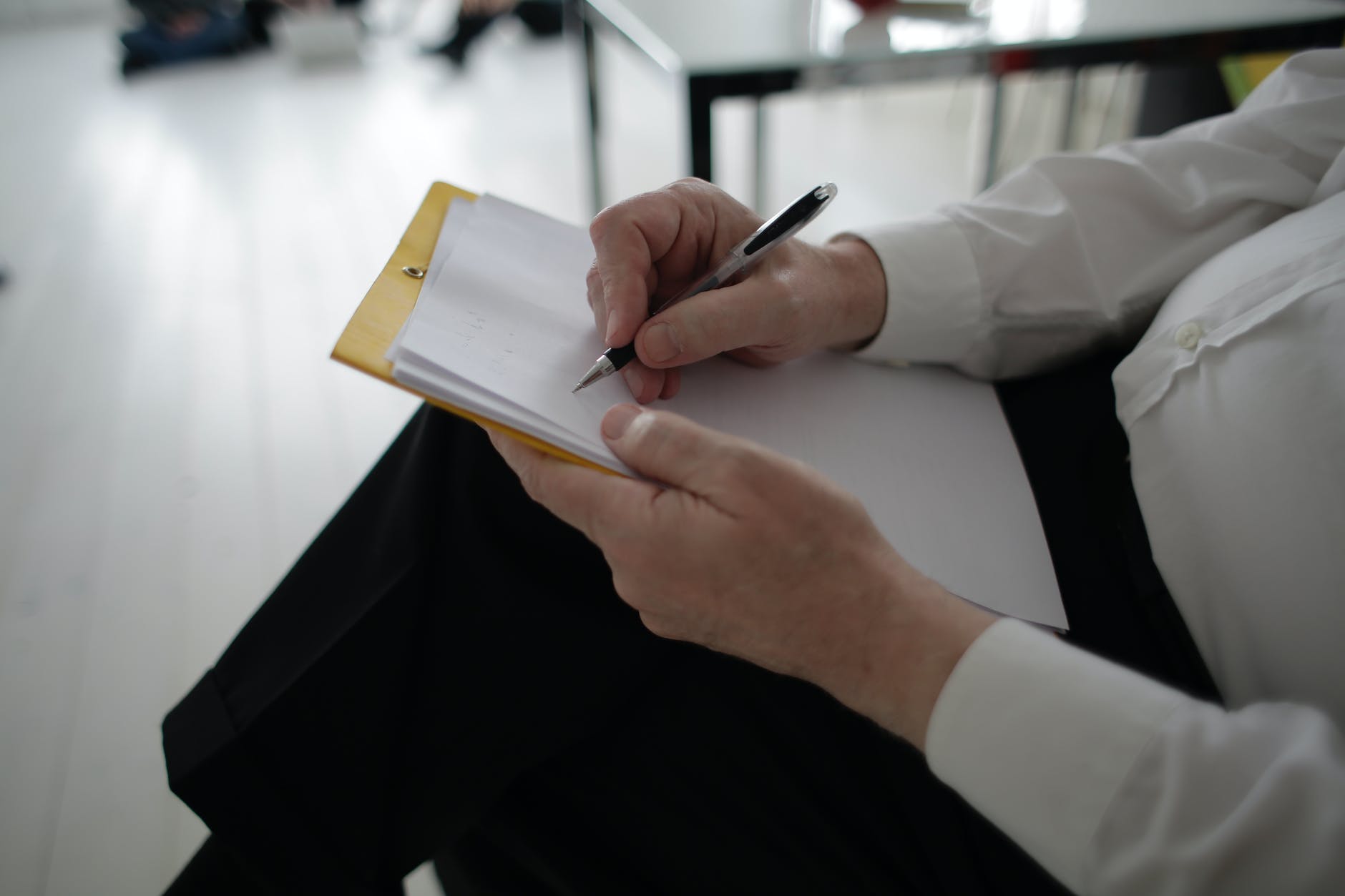 unrecognizable businessman taking notes in documents in modern office