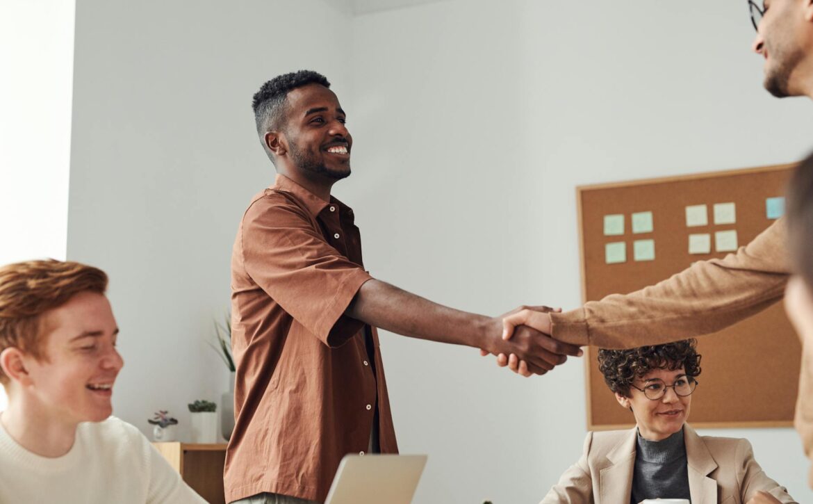 man in brown sport shirt shaking hands of man